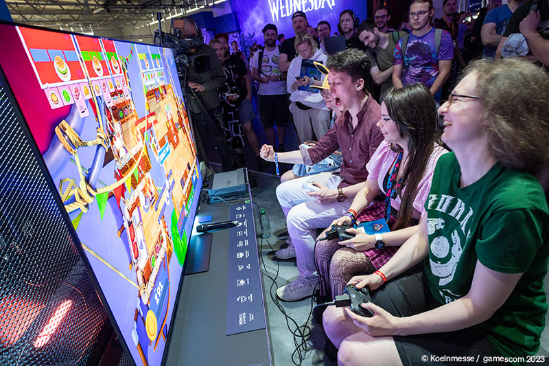 Gruppen von jungen Menschen spielen Videospiele bei der Koelnmesse, voller Energie und Begeisterung, Gaming-Event.